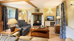 A cozy living room with a fireplace, a sofa, a coffee table, and a television. - Tyddyn Derwen, Bodnant Estate, Colwyn Bay, Conwy, Wales (Colwyn Bay)