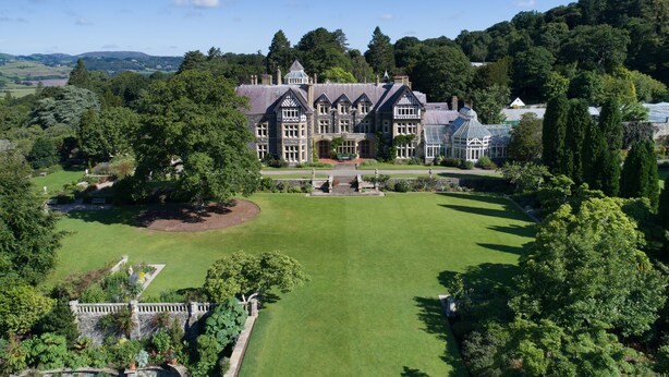 A large, historic building with a symmetrical facade, surrounded by well-manicured lawns and mature trees. - Tyddyn Derwen, Bodnant Estate, Colwyn Bay, Conwy, Wales (Colwyn Bay)