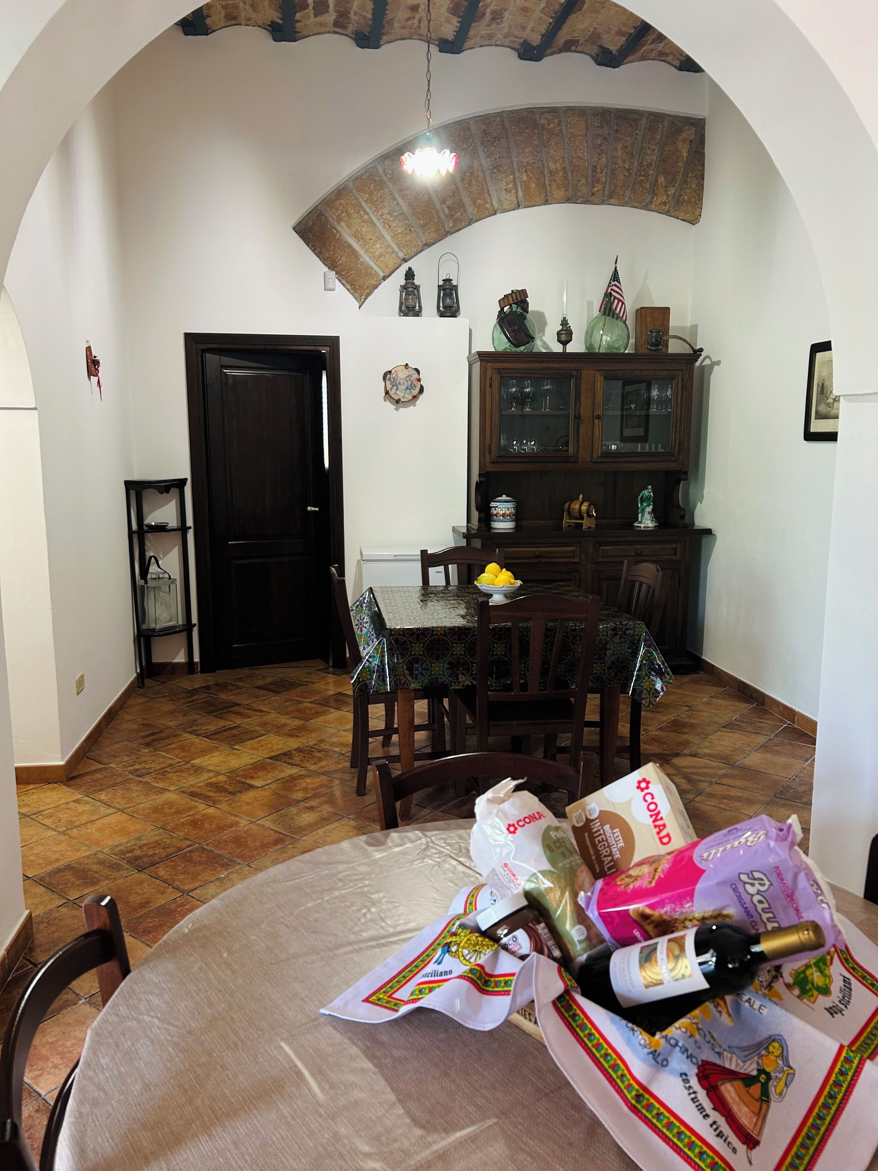 A dining area with a round table, chairs, and a cabinet with glass doors.