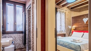 A bathroom with a sink, toilet, and a shower area. - Campiello Tron Peaceful House (Venezia)