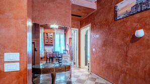 A hallway with a checkered floor, a dining area with a table and chairs, and a painting on the wall. - Campiello Tron Peaceful House (Venezia)