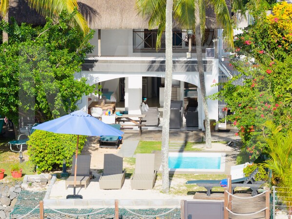 A resort with a pool, lounge chairs, and a covered patio area.