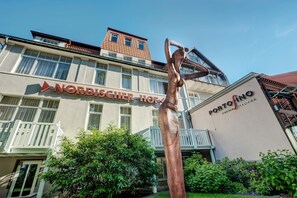 Um edifício com uma placa indicando 'Nordischer Hof' e um restaurante 'Portofino'.