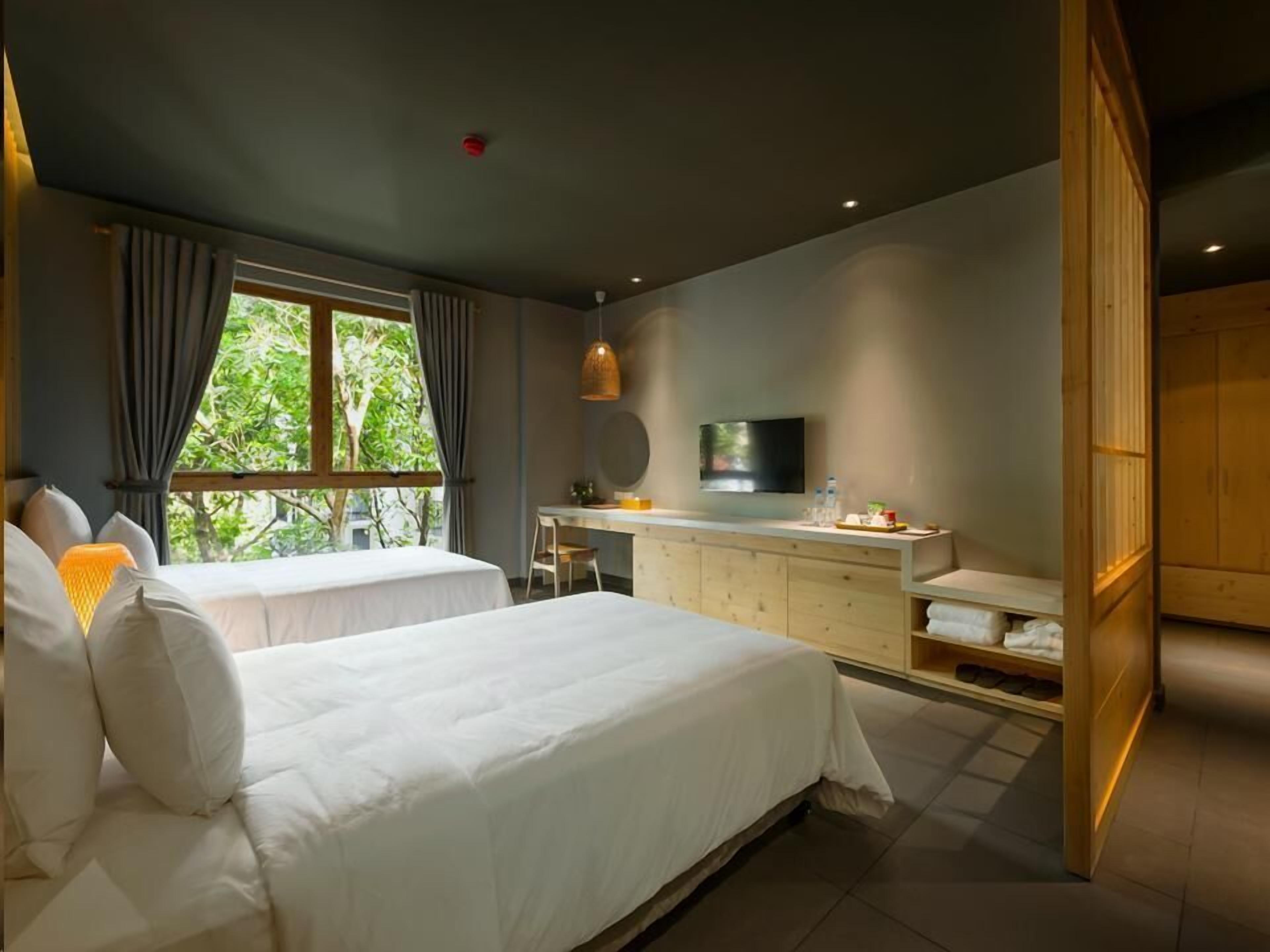 Une chambre moderne avec un grand lit, un bureau et un téléviseur.