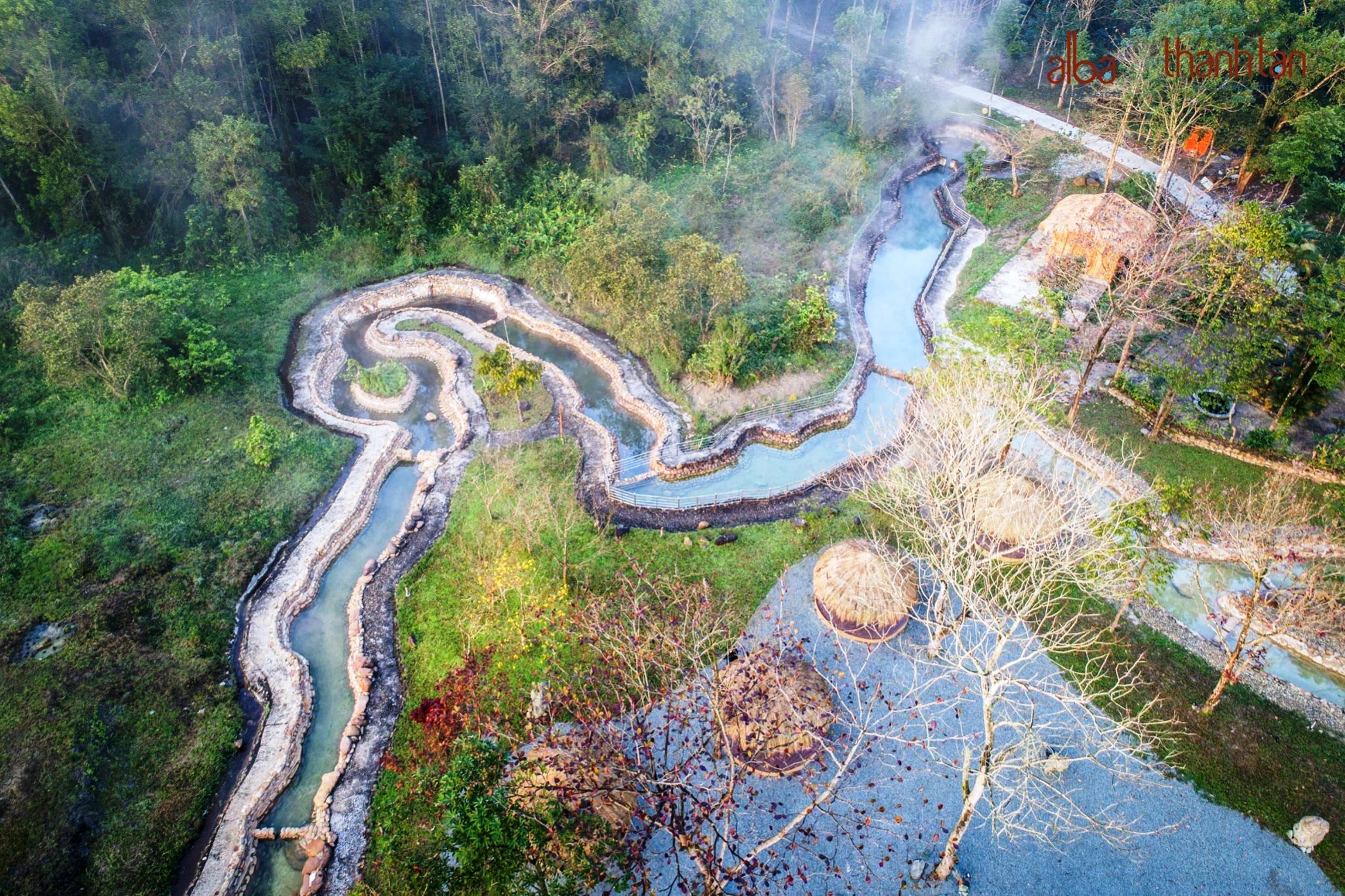 An aerial view of a terraced landscape with winding water channels and a small structure.
