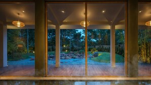 A modern interior with large glass doors leading to a garden. - Alba Wellness Resort By Fusion (Hue)