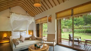 A spacious room with a bed, a sofa, a coffee table, and a view of the outdoors. - Alba Wellness Resort By Fusion (Hue)