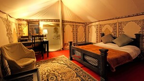 A tented room with a bed, a chair, a table, and a mirror. - Bhadrawati Safari Ranthambore Resort (Khandar)