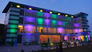 Um edifício de vários andares com projeto arquitetônico moderno, apresentando um telhado plano e grandes janelas.