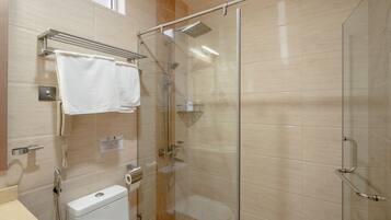 Un baño moderno con ducha de vidrio, inodoro y barra para toallas.