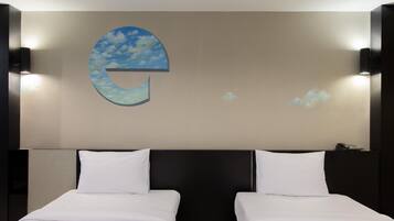 A hotel room with two beds, a large wall-mounted artwork depicting a cloud with a 'C' shape, and a phone on the nightstand.