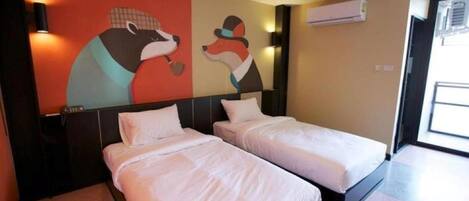 Habitación de hotel con dos camas, un mural en la pared y un equipo de aire acondicionado.
