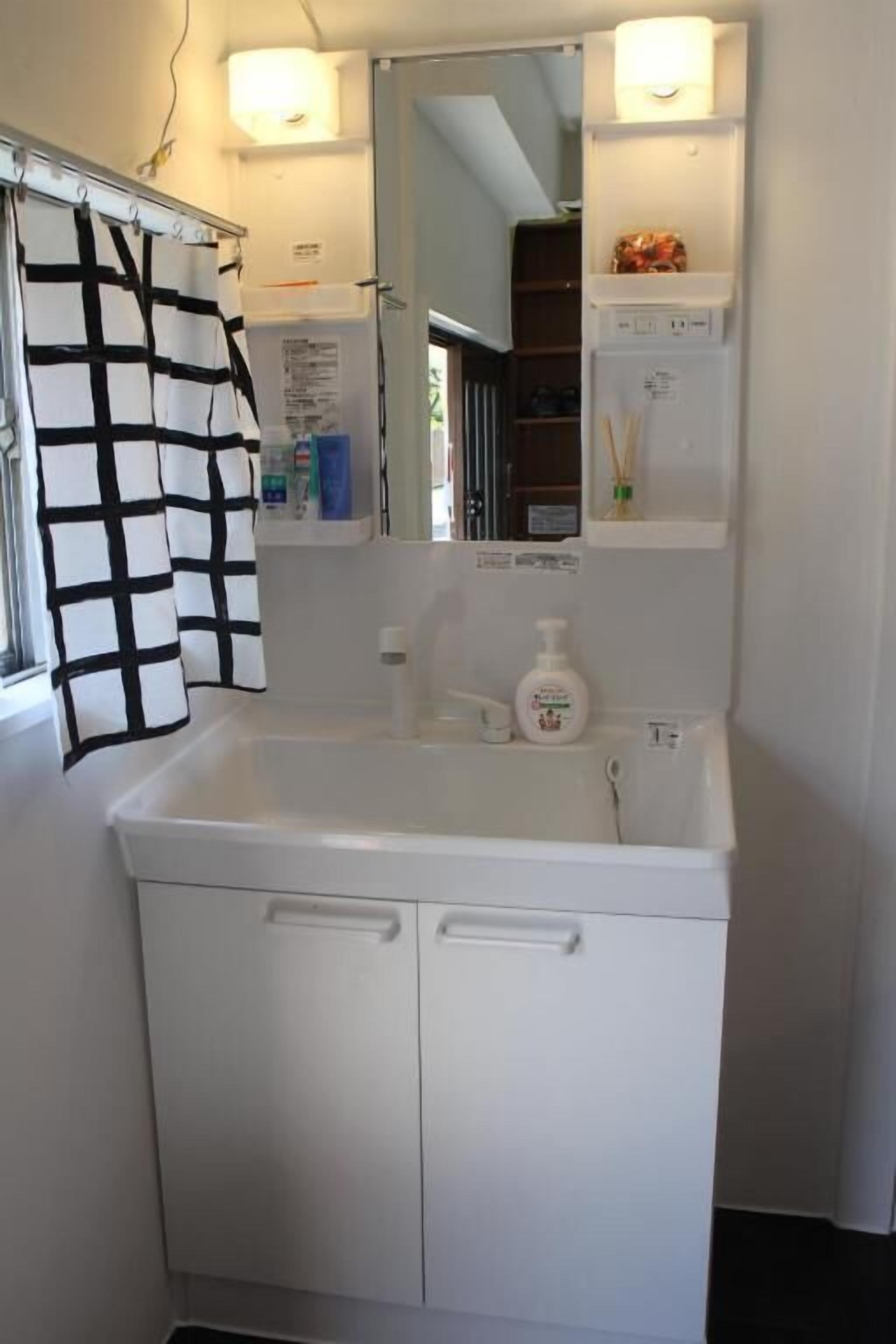 A bathroom with a white sink, a mirror, and a towel rack.