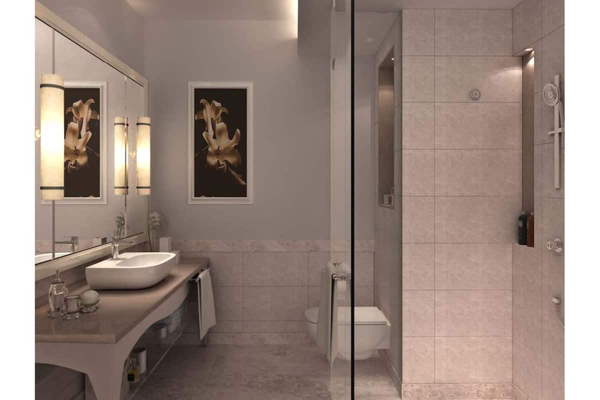 A modern bathroom with a large mirror, two framed floral paintings, a glass-enclosed shower, and a toilet.