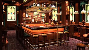 A bar area with a pool table, stools, and a variety of bottles and glasses.