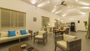 A spacious living area with a sofa, chairs, a coffee table, and a dining table. - Cashew Cashew Villa (Phu Quoc)