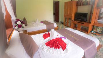 A hotel room with two beds, a television, and a cabinet with decorative items.