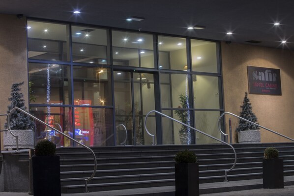 A hotel entrance with glass doors, a staircase, and Christmas decorations.