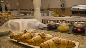 Een buffet met gebak, sauzen en een koffiezetapparaat.