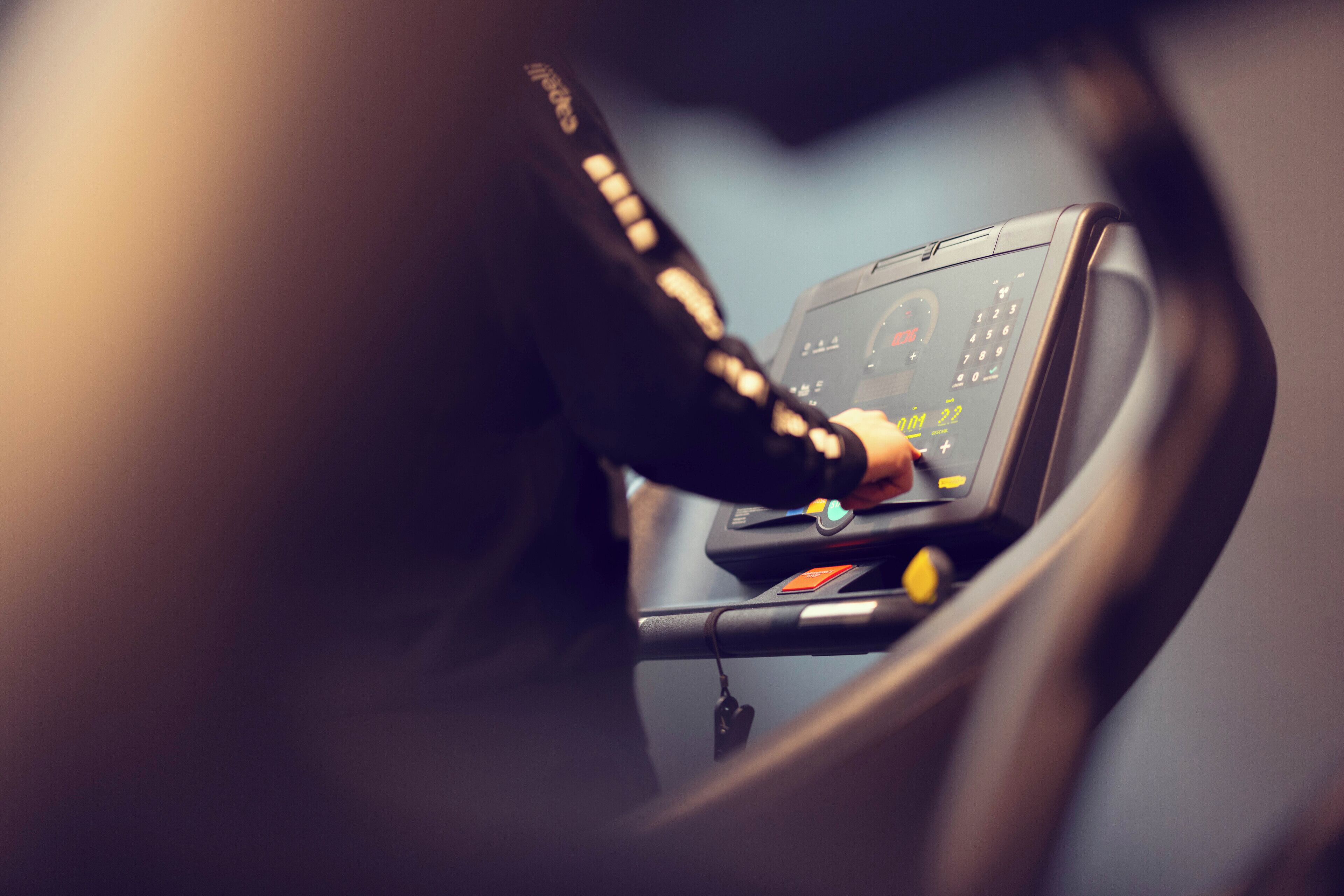 A close-up of a car's dashboard with a hand on the steering wheel.