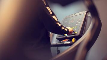A close-up of a car's dashboard with a hand on the steering wheel.
