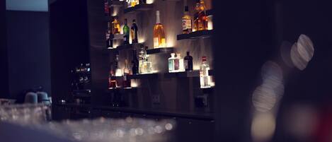A bar area with shelves of various liquor bottles and glasses.