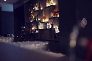 Un'area bar con scaffali pieni di bottiglie di liquori e bicchieri.