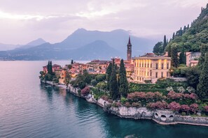 A lakeside town with historic buildings, a prominent tower, and a stone bridge. - Hotel Villa Cipressi - by R Collection Hotels (Varenna)