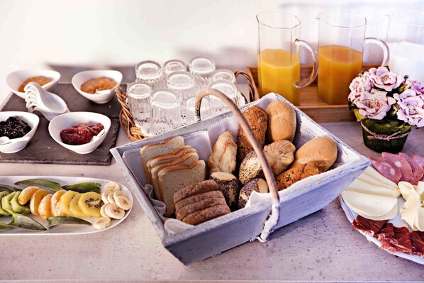 Un buffet de petit-déjeuner proposant un assortiment de pains, de viennoiseries et de fruits.