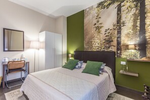 Relax in comfort with a large bed, nightstand, and desk, surrounded by a nature-inspired mural.