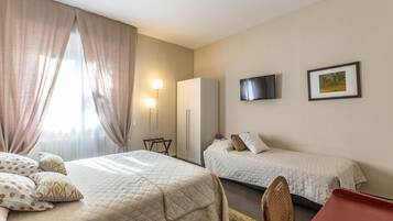 Une chambre d’hôtel avec deux lits, une télévision, un bureau et une chaise.