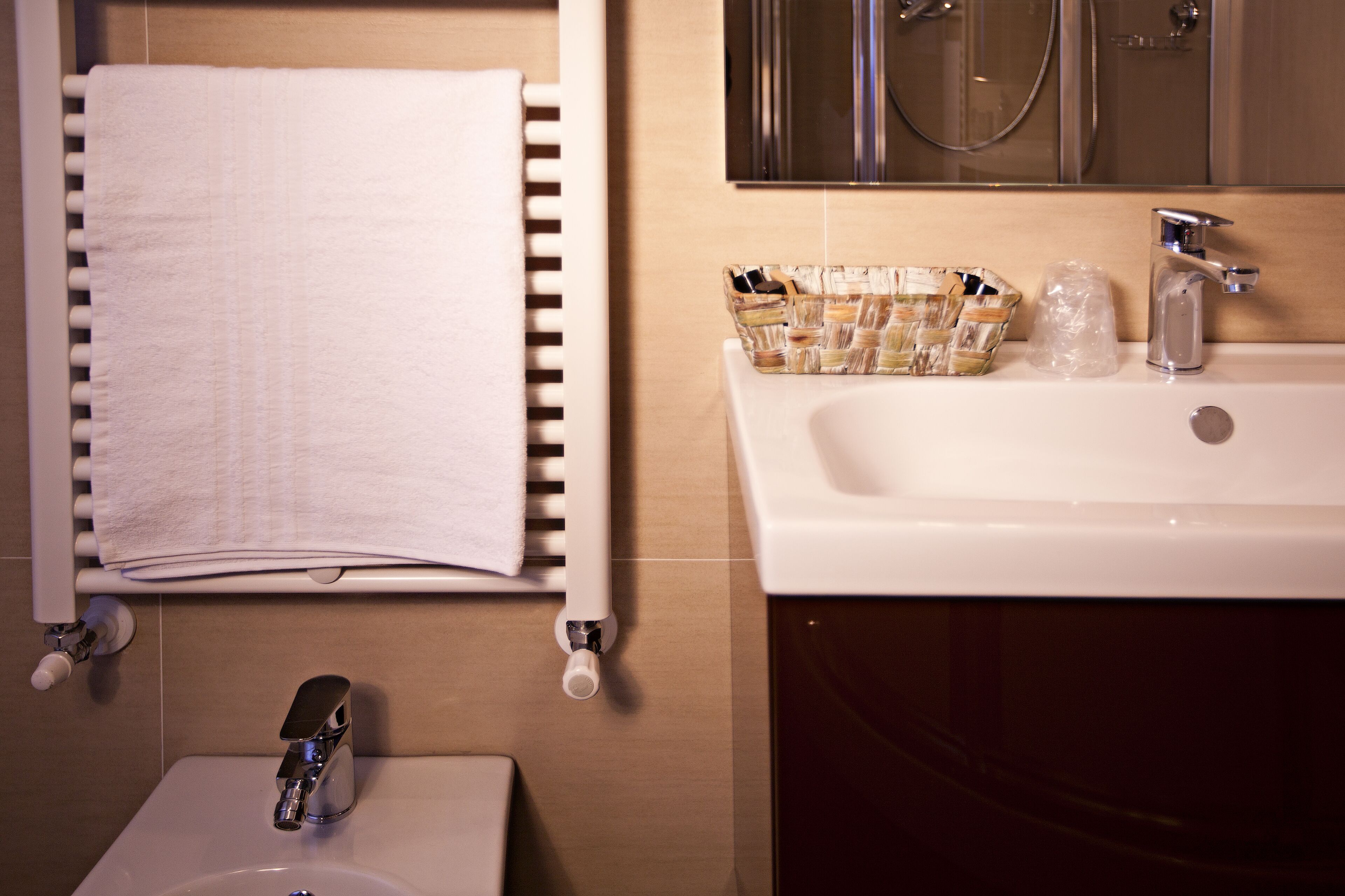A bathroom with a white sink, a mirror, and a towel rack.