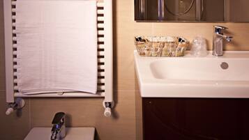 A bathroom with a white sink, a mirror, and a towel rack.