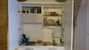 A compact kitchen with white cabinets, a built-in sink, and a small countertop. - Svegliarsi nei Borghi - La Patronale (Troia)