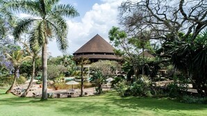 A resort with a large circular building, lush greenery, and outdoor seating areas. - SAFARI PARK HOTEL (NAIROBI)