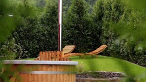 A wooden deck with a metal structure, surrounded by lush greenery and trees. - Holiday directly on the Reinhardswald (Trendelburg)