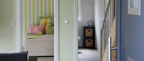 Una habitación con una cama, un escritorio y una escalera.