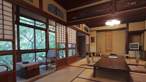 A traditional Japanese room with tatami flooring, a wooden table, tatami mats, and sliding doors.