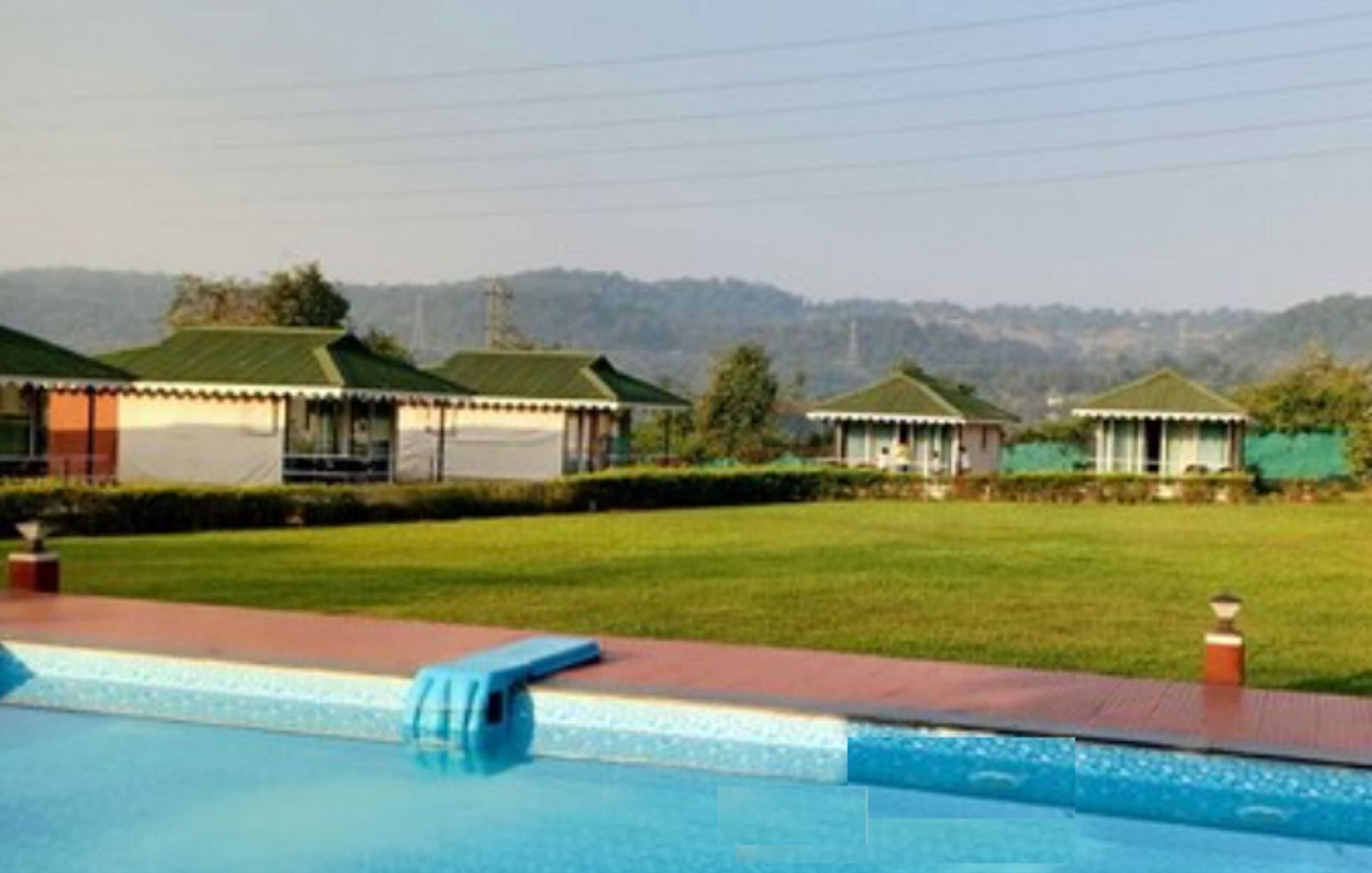A pool area with a clear view of the surrounding landscape, including a series of small buildings with green roofs.