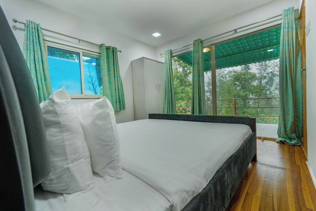 Un dormitorio con una cama grande, un armario y una ventana con cortinas.
