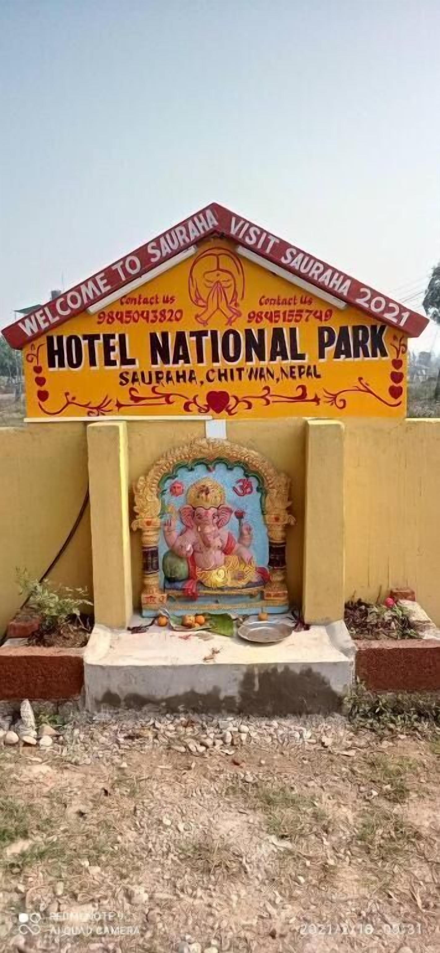 Schild für das Hotel National Park in Saupaha, Chitwan, Nepal, mit Kontaktnummern und einer Darstellung einer Gottheit.