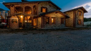 A stone building with multiple windows and a gravel driveway. - Cascina Veja (Chiusa di Pesio)