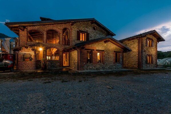 A stone building with multiple windows and a gravel driveway. - Cascina Veja (Chiusa di Pesio)