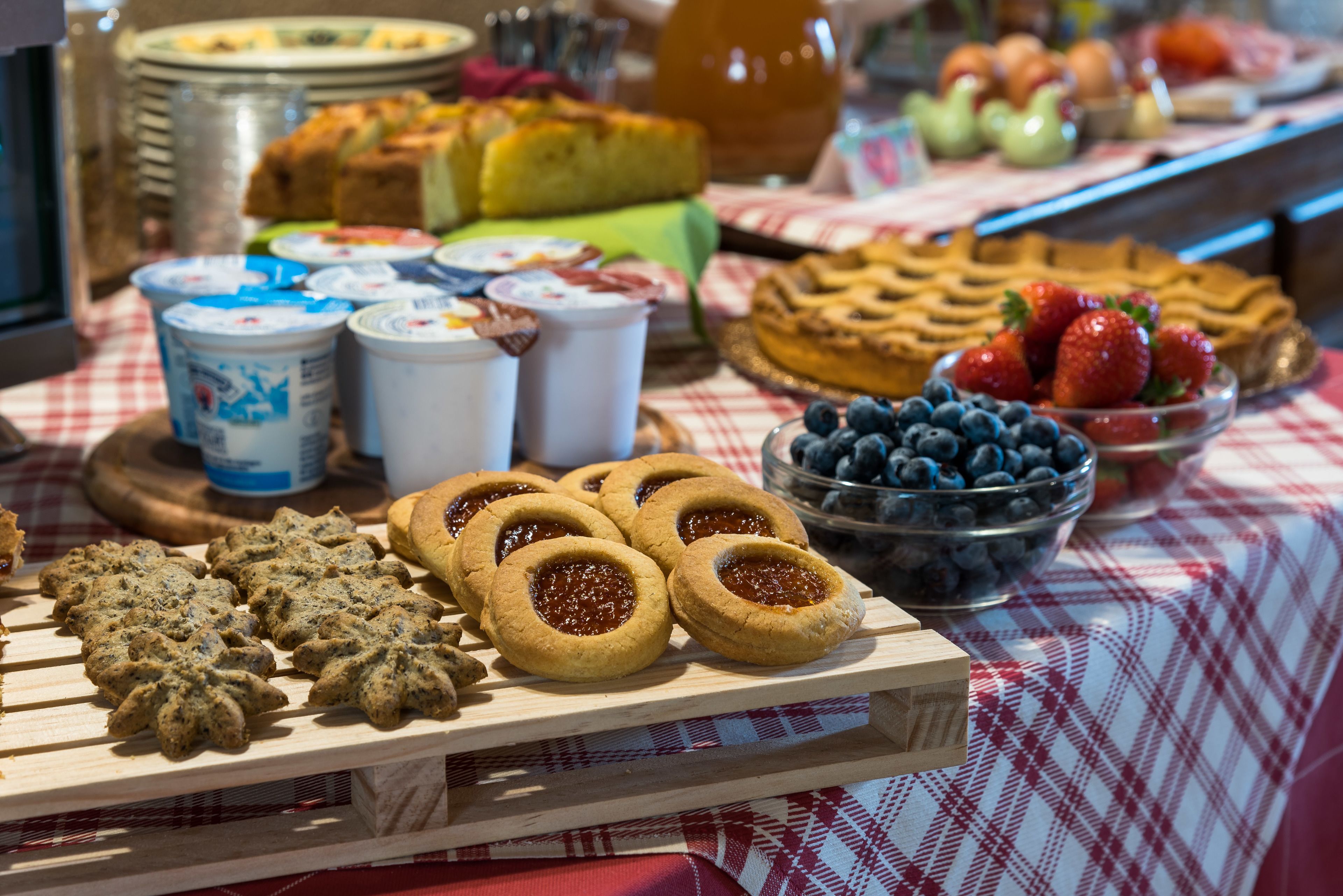 A buffet table with various food items including cookies, jams, and fresh fruits.
