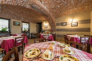 A restaurant with brick ceiling, checkered tablecloths, and traditional table settings. - Cascina Veja (Chiusa di Pesio)