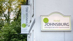 Un letrero para el Hotel Johnsburg, con un logo verde y texto que indica que es un hotel moderno y céntrico.