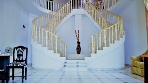 A white spiral staircase with a vase in the center. - PJ Lodge (Dar es Salaam)