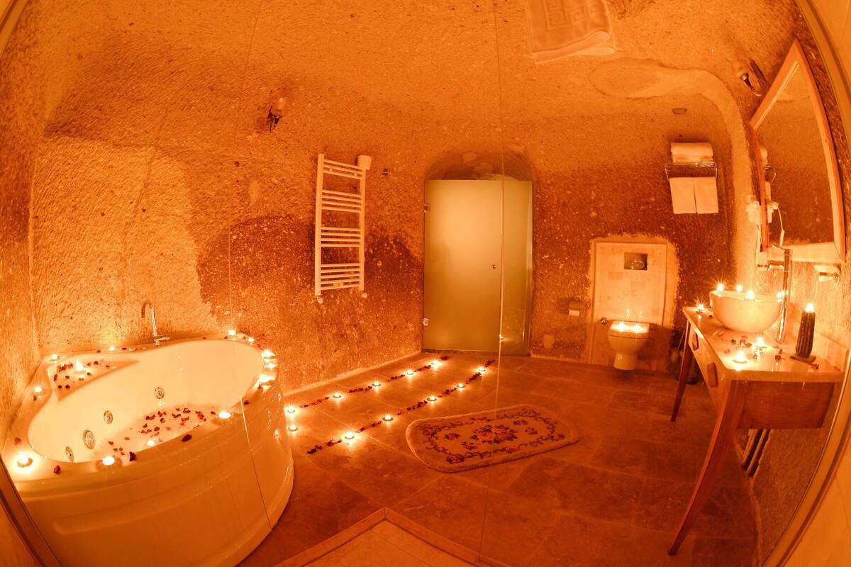 A bathroom with a bathtub, toilet, sink, and a mirror.