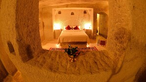 A room with a bed, a decorative bowl, and a patterned rug. - Mosaic Cave Hotel (Nevsehir)