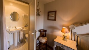 A bathroom with a sink, toilet, and chair. There is a mirror, a lamp, and a framed picture on the wall. - Chambres D'hotes La Barbinais Bed&breakfast St Malo (Saint-Malo)